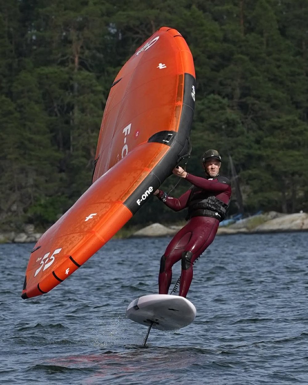 Jørgen wingfoiling, airborne above the water on a hydrofoil